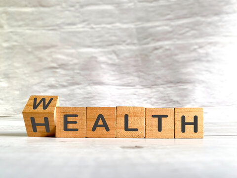 Wooden blocks flipped from wealth to health for wellness and healthy living concept