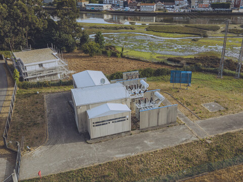 Aerial view of Subestacao E-Redes Gondomar electrical substation with metal structures and transformers near a riverbank in Sao Cosme, Porto District, Portugal.