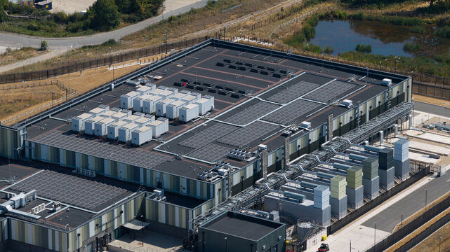 Aerial view of the Datacentre featuring extensive rooftop solar panels and industrial cooling units in Didcot, England, United Kingdom.