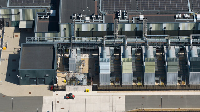 Aerial view of the Datacentre featuring industrial cooling units, rooftop solar panels, and a secure perimeter fence in Didcot, England, United Kingdom.