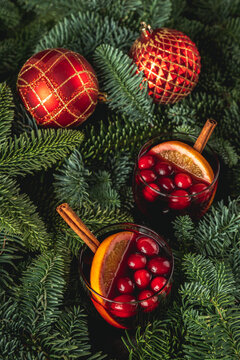 Mulled wine with orange, cranberry and cinnamon in fir forest setting. Selective focus.