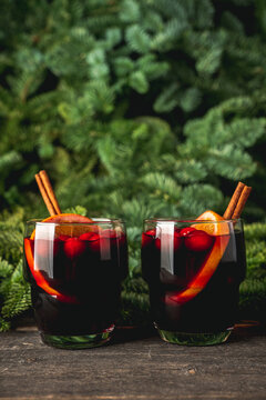 Mulled wine with orange, cranberry and cinnamon in fir forest setting. Selective focus.