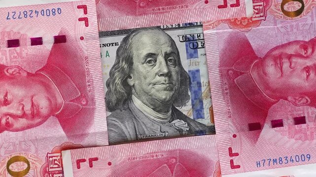 Rotating USD 100 bill against a background of Chinese yuan (CNY) or renminbi (RMB) banknotes. Concept of finance, international trade, currency value, banking and global economy