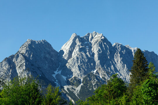 Travel landscape of Zugspitze Alps in Bavaria, Germany, scenic summer nature panorama with forest, snow mountains peak. Alpine landscape
