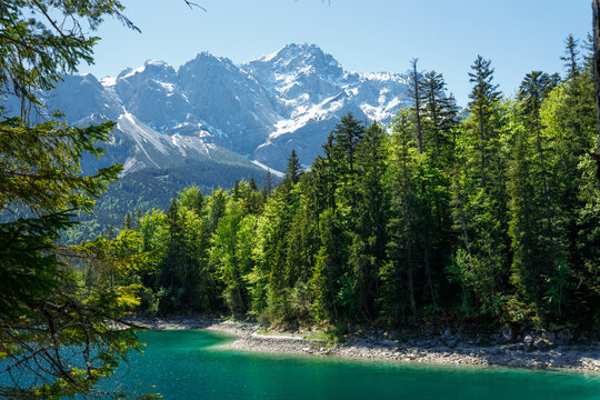 Travel landscape of Zugspitze Alps in Bavaria, Germany, scenic summer nature panorama with forest, Eibsee lake, snow mountains peak. Alpine landscape