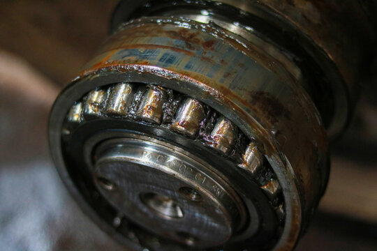 Extreme Close Up of Heavy Industrial Tapered Roller Bearing Covered in Grease