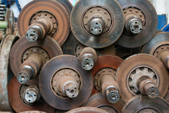 Stacked Steel Train Axles and Brake Rotor Assemblies in Maintenance Workshop