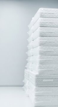 A tall stack of plush white mattresses stands organized in a clean warehouse space, ready for logistical shipping to residential addresses, cushion, plush, warehouse