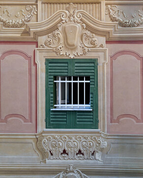 Traditional Ligurian trompe l oeil painted window facade with real white iron guardrail in Genoa, Liguria, Italy