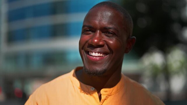 African american businessman laughing and smiling, closeup headshot portrait outdoor near office building. Black business man works as business executive, cheerful expression outdoors, collaborating.