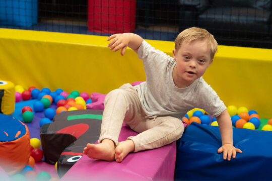 Boy with Down Syndrome Playing in Colorful Indoor Soft Play Area