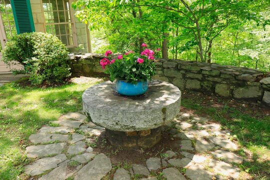 Flowerpot on pedastal in woodsy enclosure