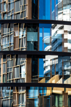 Reflections on a contemporary building facade showing glass windows and urban city architecture exterior