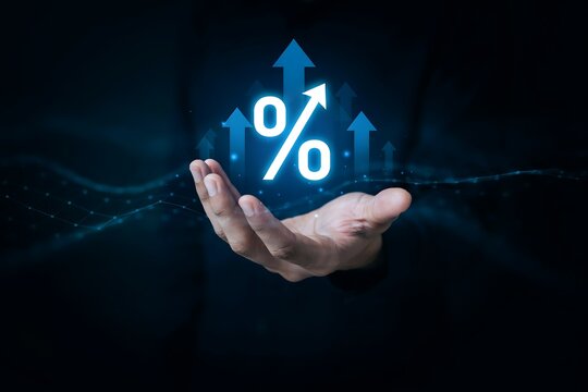 Hand holding glowing percentage icon with rising arrows for financial growth and interest rate