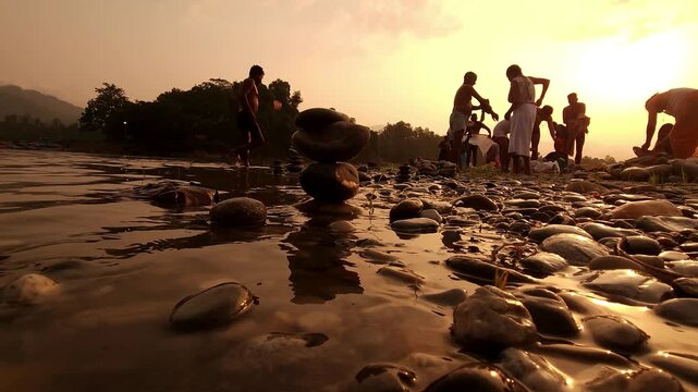 Defocused Sacred River Bathing at Sunrise at Devghat Dham, Nepal, with Balanced River Stones in Foreground, Hindu Pilgrimage, Spiritual Ritual, Golden Morning Light and Riverside Culture