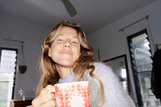 UGC Woman holding coffee mug during flash morning portrait at home