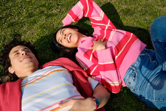 Two Friends Lying on Grass Looking Up