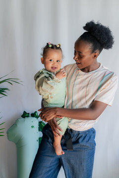 Young mother holding her little child in arms 