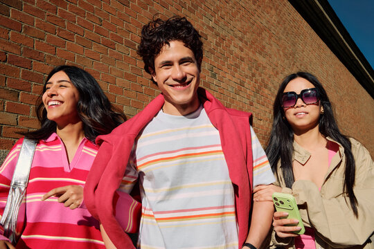 Three Friends Laughing Against Brick Wall
