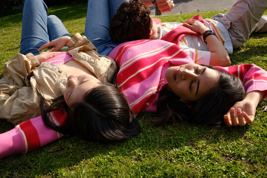 Three Friends Resting Together on Grass