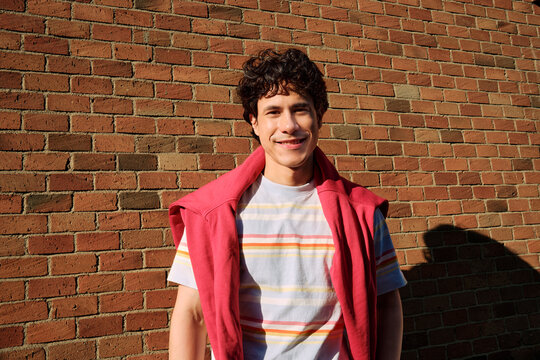 Young Man Smiling Against Brick Wall