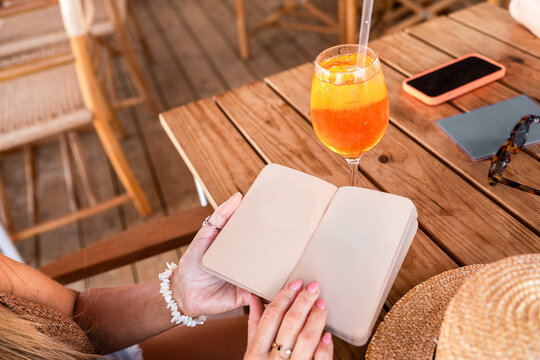 Open Journal And Aperol Spritz On A Sunny Terrace