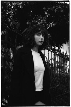 Curly-haired woman by iron fence