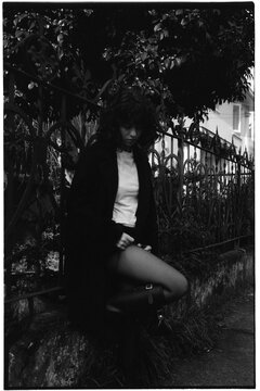 Young woman with curly hair looking down and adjusting tights