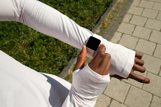 Young black runner man checking his running stats on smartwatch.