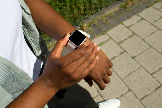 Young black runner woman checking his running stats on smartwatch.