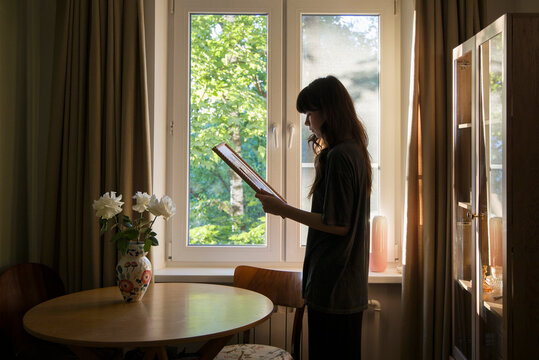 looking at the phot by the window in a cozy room during daylight hours