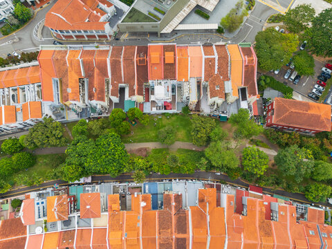 Green belt and pathway between row houses with terracotta tiled roofs