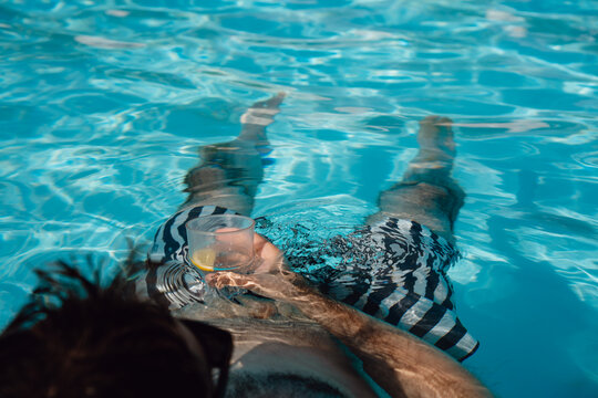 Floating in Swimming Pool With a Summer Drink