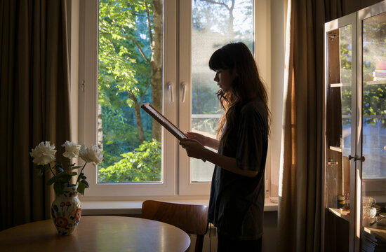 looking at the phot by the window in a cozy room during daylight hours