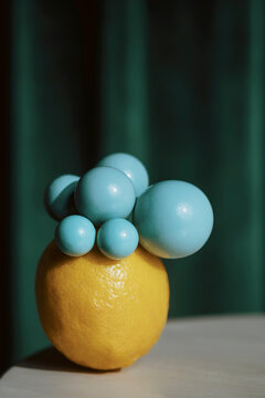 Creative Display of Blue Spheres on a Lemon on a Table
