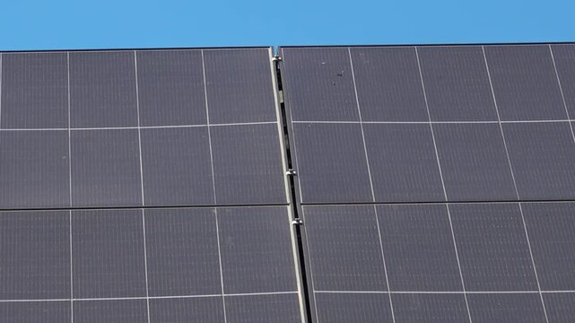 Solar panels installed on the roof of a city building. Concept of eco friendly and alternative power source. 