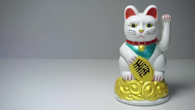 Chinese lucky cat Maneki Neko waving paw decorative figurine close up