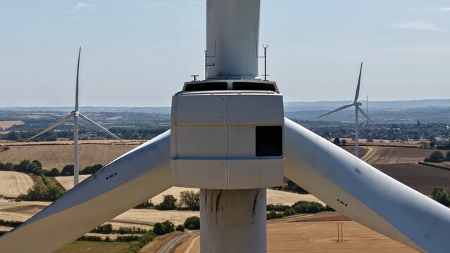 Aerial view of Penny Hill Wind Farm featuring a close-up of a wind turbine nacelle and blades set against a rural landscape in Aston, England, United Kingdom.