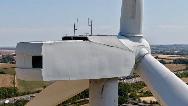 Aerial view of Penny Hill Wind Farm featuring a wind turbine nacelle and blades set against a rural landscape with a highway in the background in Aston, England, United Kingdom.