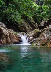 Sanzhanxi River cascades into a turquoise pool in Taroko National Park. Lush forest surrounds the rocky gorge. Hualien, Taiwan landscape view. © Eugene Ga