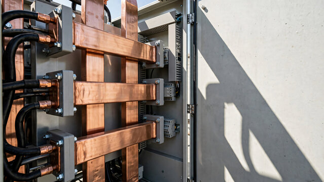 Close up of heavy copper busbars and electrical conductors inside industrial switchgear cabinet