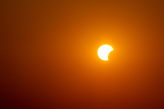 Beginning of solar eclipse seen from Croatian coast, on august, 12th, 2026, during the golden hour when sun was setting together with a moon  on a clear  orange sky creating wonderful summer memory