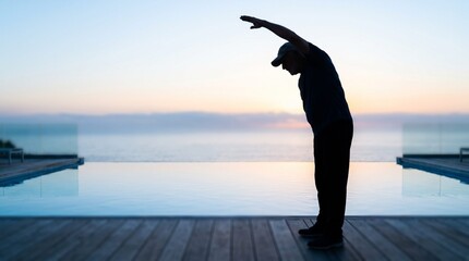 Fototapeta premium Silhouette of Senior Man Performing a Side Stretch at Sunset