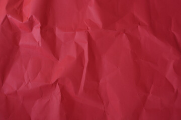 Fototapeta premium Crumpled red paper texture background with deep wrinkles, folds, and subtle shadows