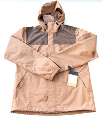 Brown and Tan Hooded Rain Jacket with Tag on White Background © YouraPechkin