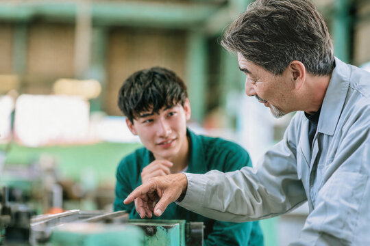 技能継承のため若手社員を教育するベテラン技術者