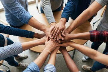 Obraz premium Diverse group of business people stacking hands together on table showcasing teamwork with teamwork business strength