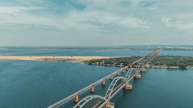 Aerial view of the Godavari Arch Bridge spanning the river with its distinctive steel arches, surrounded by sandbanks and lush greenery in Rajamahendravaram, Andhra Pradesh, India.