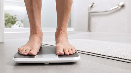 Fototapeta premium Person standing on bathroom scale, checking weight and monitoring diabetes management with focus on healthy lifestyle, control over nutrition, and glucose levels for better health outcomes.
