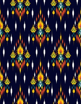 Traditional ethnic ikat seamless pattern with colorful motifs on dark blue